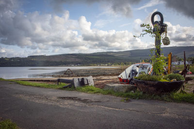 Abandoned vehicle on land against sky