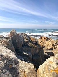 Scenic view of rocks on beach against sky