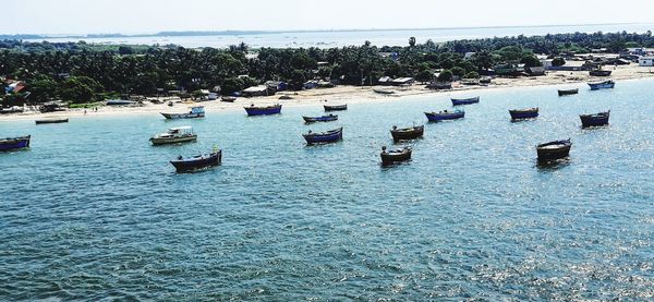 Boats moored in sea against sky