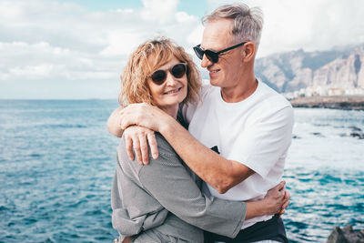 Portrait of young woman wearing sunglasses against sea