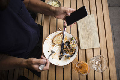 Midsection of man holding ice cream on table