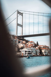 Bridge over sea against buildings in city