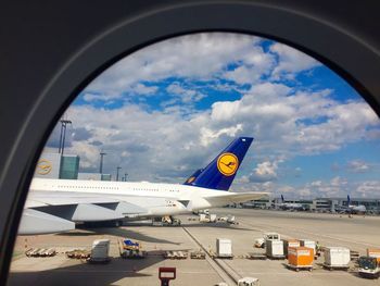 Airplane on airport runway against sky