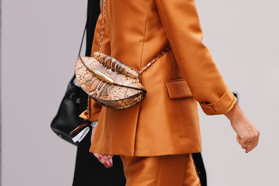 Midsection of woman standing against white background