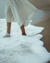 Low section of woman standing on snow