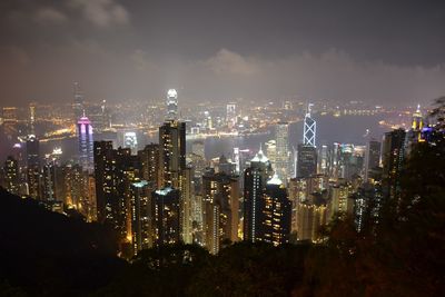 High angle view of victoria harbor amidst illuminated buildings in city