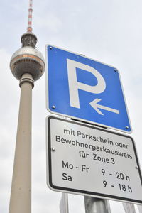 Low angle view of information sign against sky