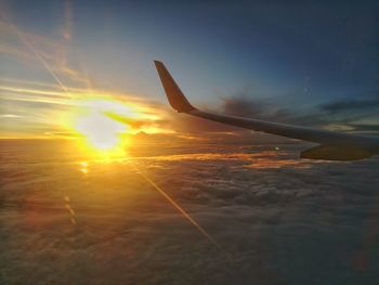 Airplane on runway against sky during sunset