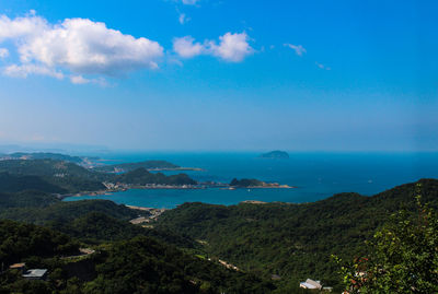 Scenic view of sea and mountains against blue sky