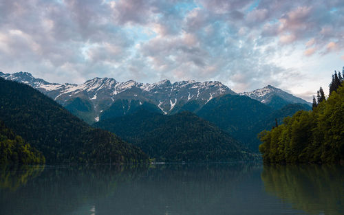 Scenic view of lake by mountains against sky