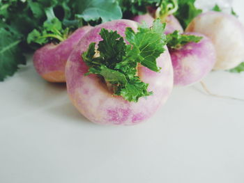 Close-up of fresh turnips on white table