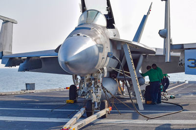 Rear view of worker working at airplane