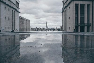 Buildings in city against cloudy sky