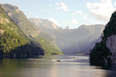 Scenic view of river and mountains against sky