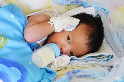 High angle view of baby boy lying on bed