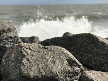 Close-up of rocks by sea against sky