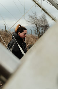 Low angle view of young woman standing on railroad track