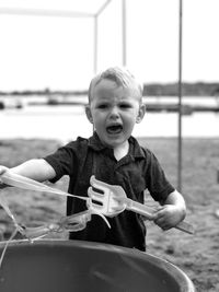 Angry baby boy shouting while standing at beach