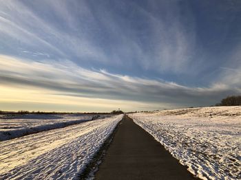 View of snow covered land against sky