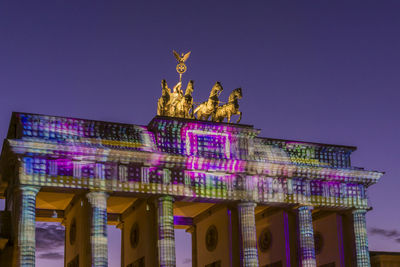 Statue in city at night