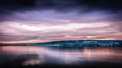 Scenic view of lake against sky at sunset