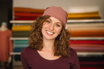 Curly-haired woman posing confidently in her workshop