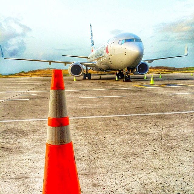 transportation, mode of transport, air vehicle, airplane, flying, travel, sky, red, mid-air, land vehicle, day, on the move, public transportation, airport runway, cloud - sky, journey, blue, outdoors, airport, car