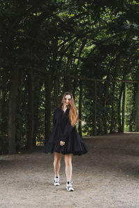 Full length of woman standing in forest