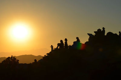 Low angle view of silhouette people against sky during sunset
