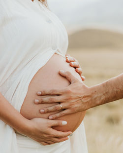 Midsection of couple holding hands