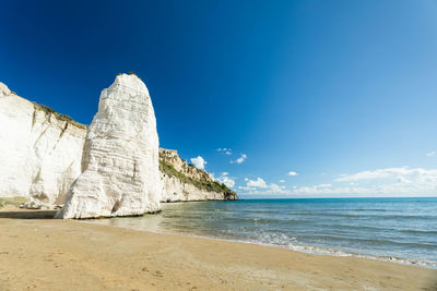 Scenic view of beach against blue sky