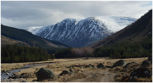 Scenic view of snowcapped mountains against cloudy sky