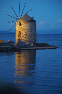 Built structure by sea against blue sky