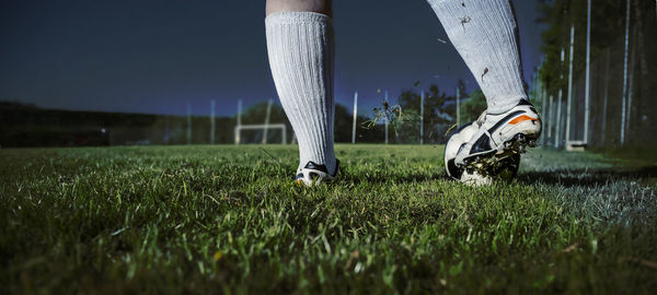 Low section of person playing with soccer ball on field