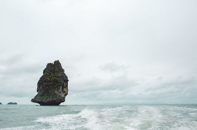 Rock formation in sea against sky