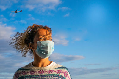 Close-up of woman wearing mask looking away while standing outdoors