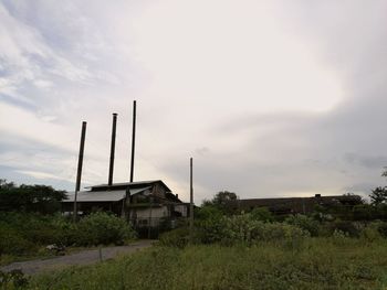 Traditional windmill on field against cloudy sky