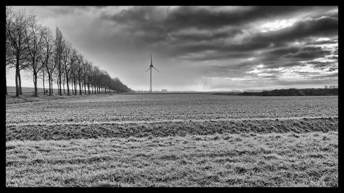 Scenic view of field against cloudy sky