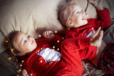 High angle view of girls lying on bed at home