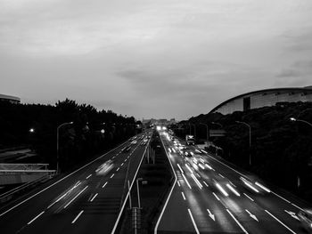 Light trails on road in city against sky