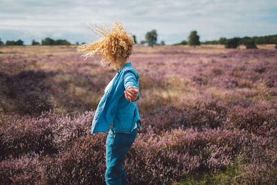 Rear view of woman standing on field