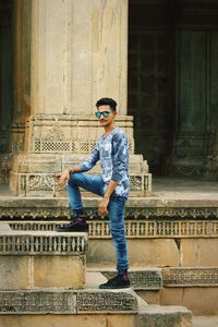 Man wearing sunglasses sitting on staircase