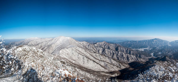Panoramic view of mountain range against blue sky