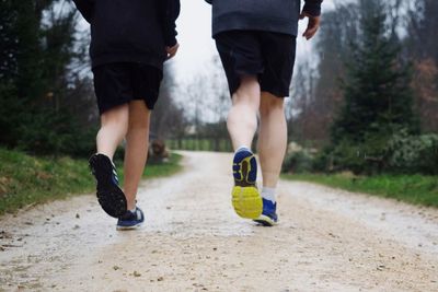 Low section of men running on footpath