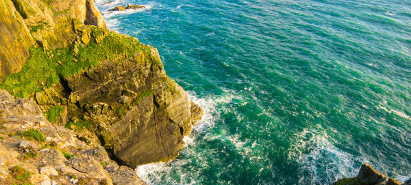 High angle view of rock formations by sea