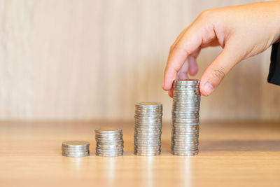 Close-up of hand holding stack of coins