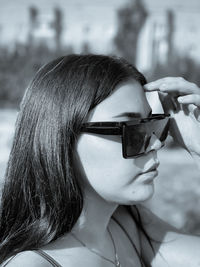 Close-up portrait of woman holding sunglasses