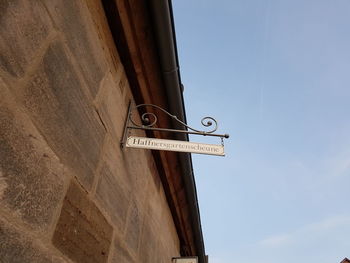 Low angle view of road sign against clear sky