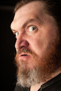 Close-up portrait of man against black background