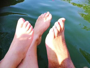 Low section of woman relaxing in water